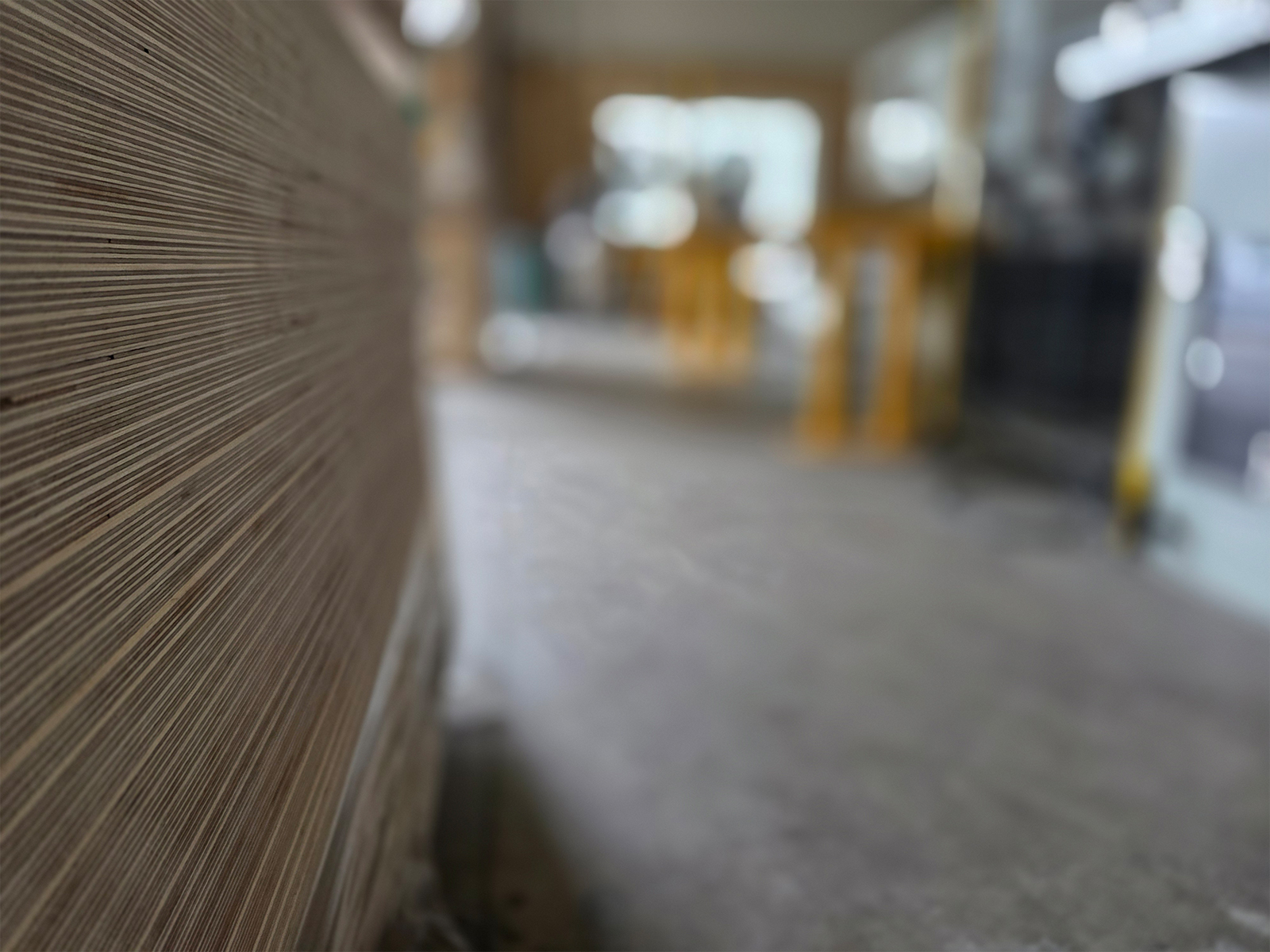 The layered edges of Baltic Birch sheets in close-up inside the Sarivale workshop.