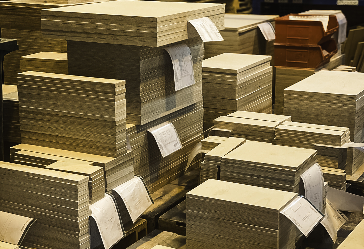 Batches of machined Baltic Birch panels stacked with their job drawings in the Sarivale workshop.