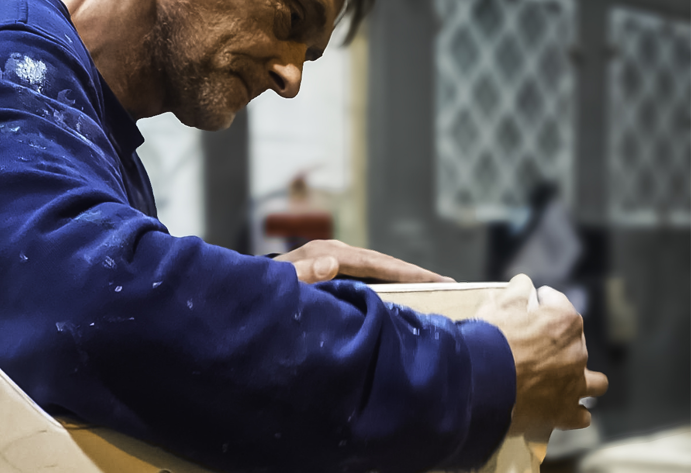 A Sarivale craftsman checking a cabinet panel by hand during assembly.