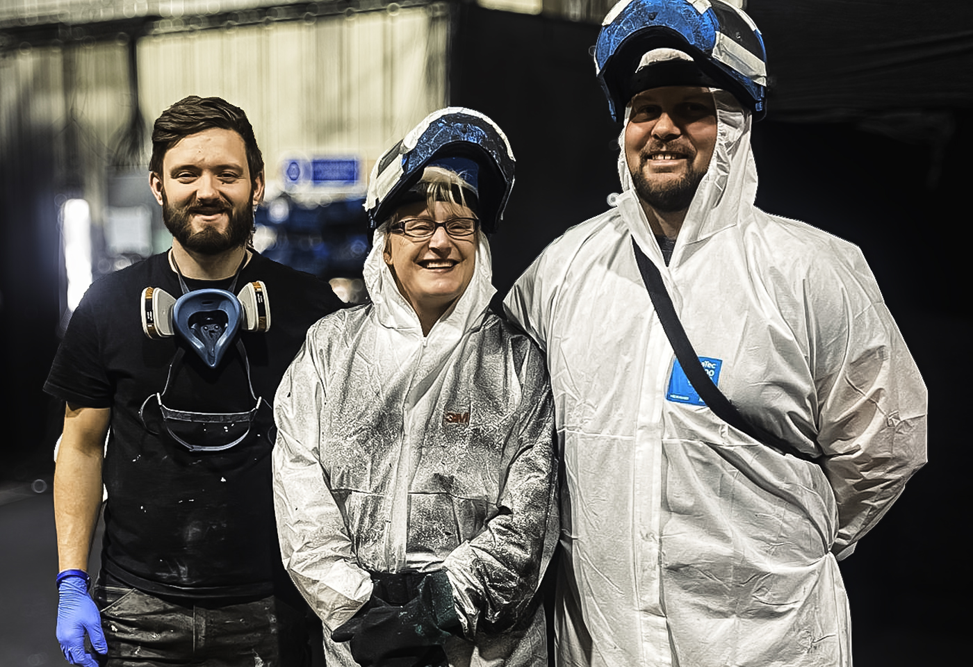 Three of the Sarivale spray shop team in protective suits and spray visors.