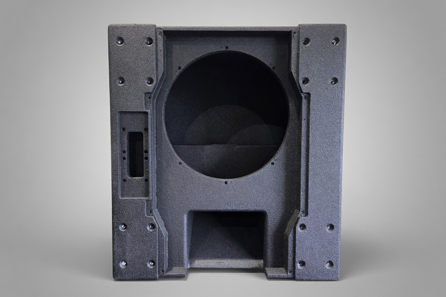 Finished black speaker cabinets stacked in the dispatch area, ready to ship.